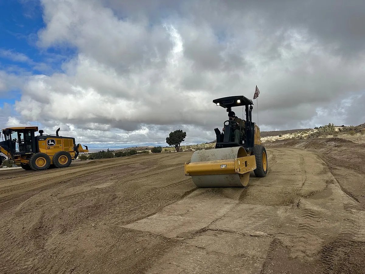 Roller compacting a gravel base for a parking pad
