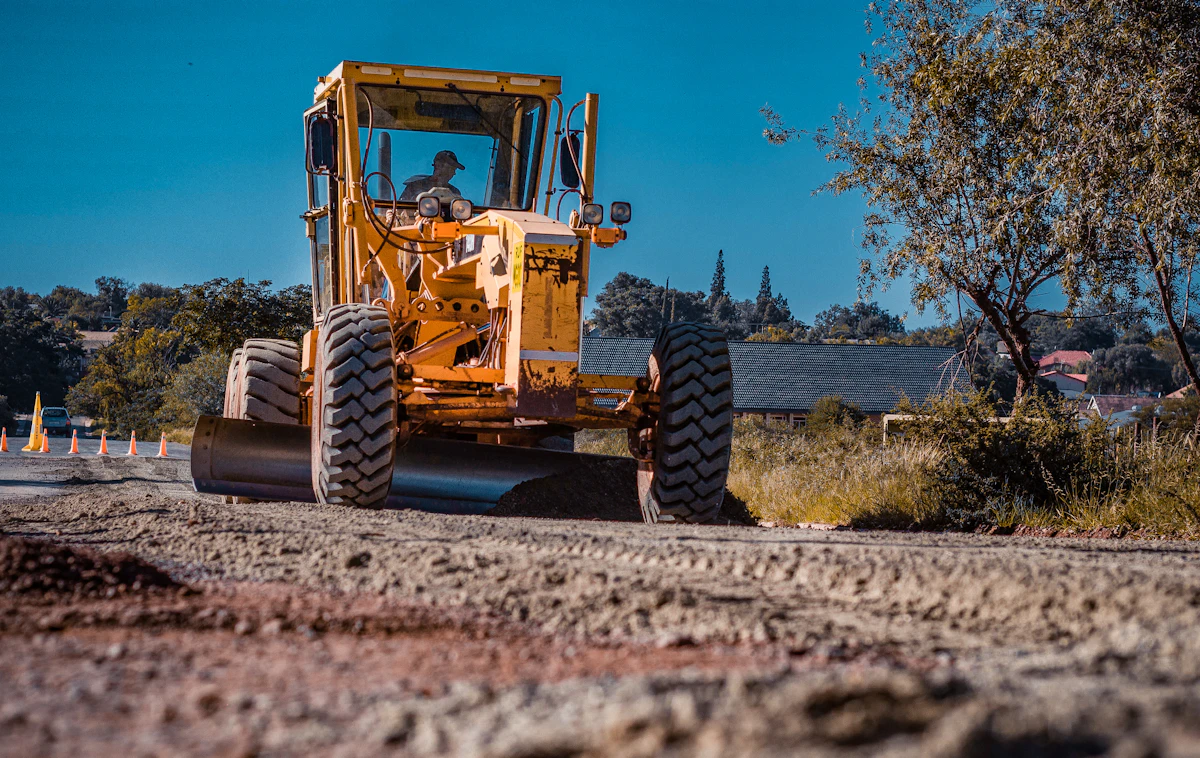 Road grader grading a gravel driveway in Forney TX